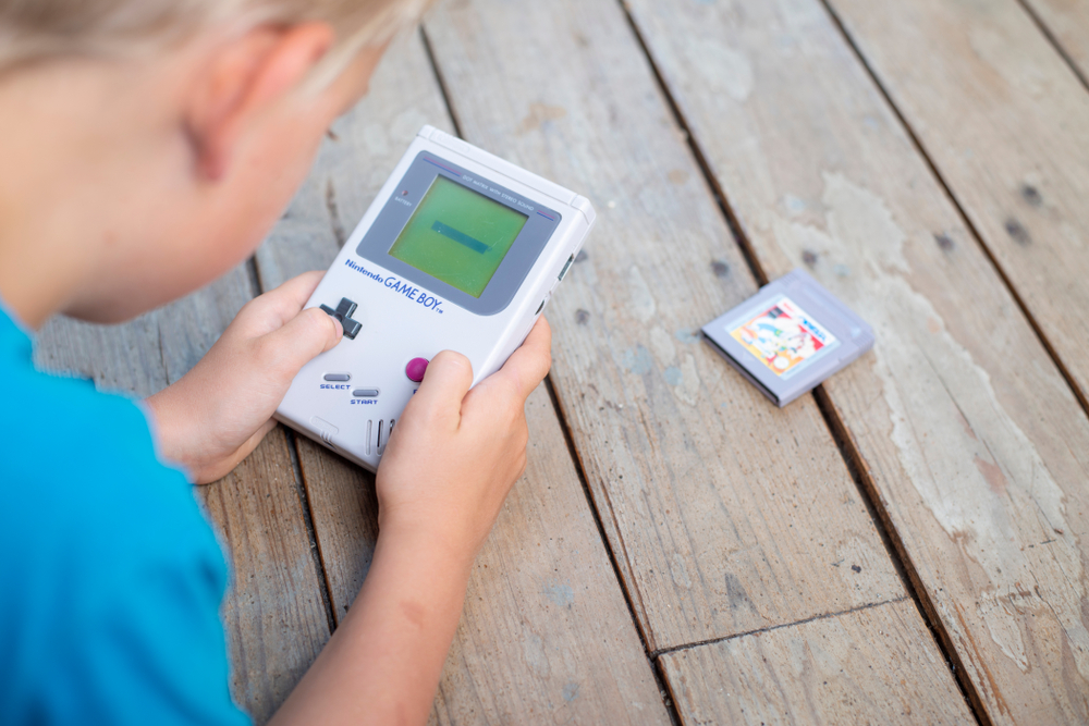 Young kid playing on a Nintendo Gameboy