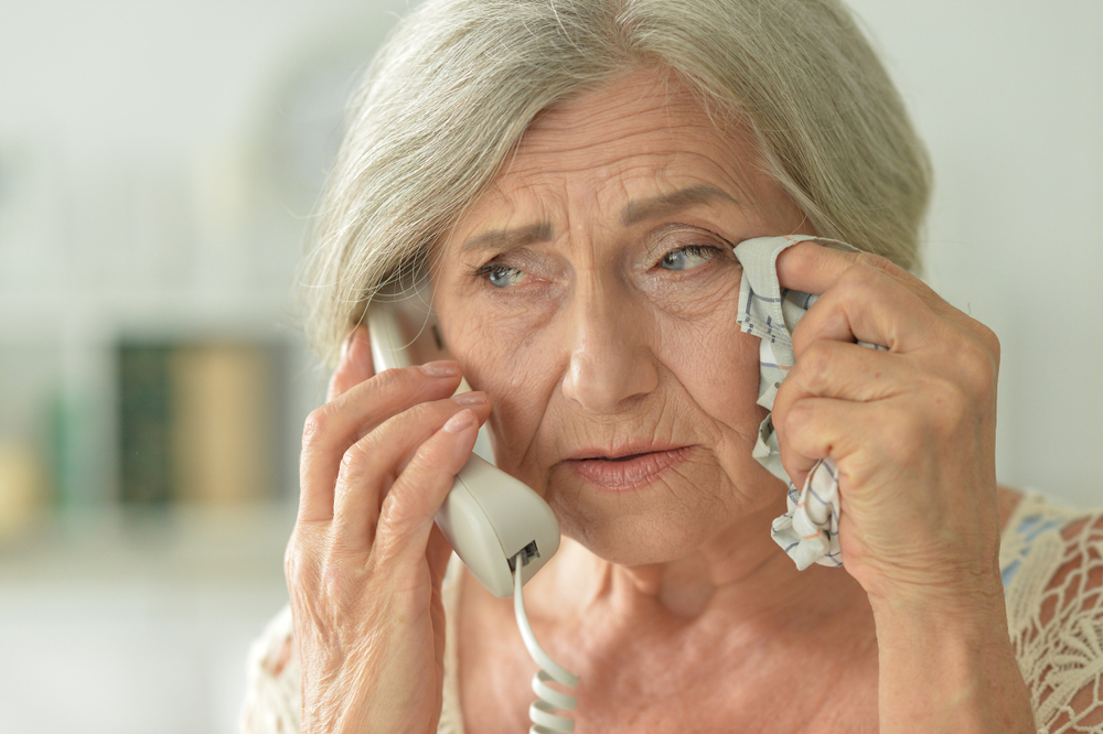 upset senior woman on phone