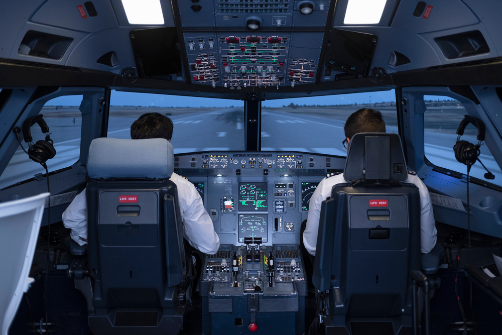 two pilots sitting in their seats preparing to start the flight