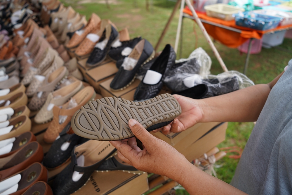 Man buying shoes at a secondhand market place