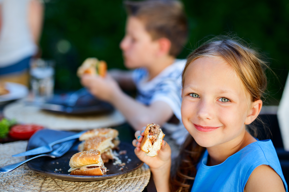 Adorable little girl and her family eating