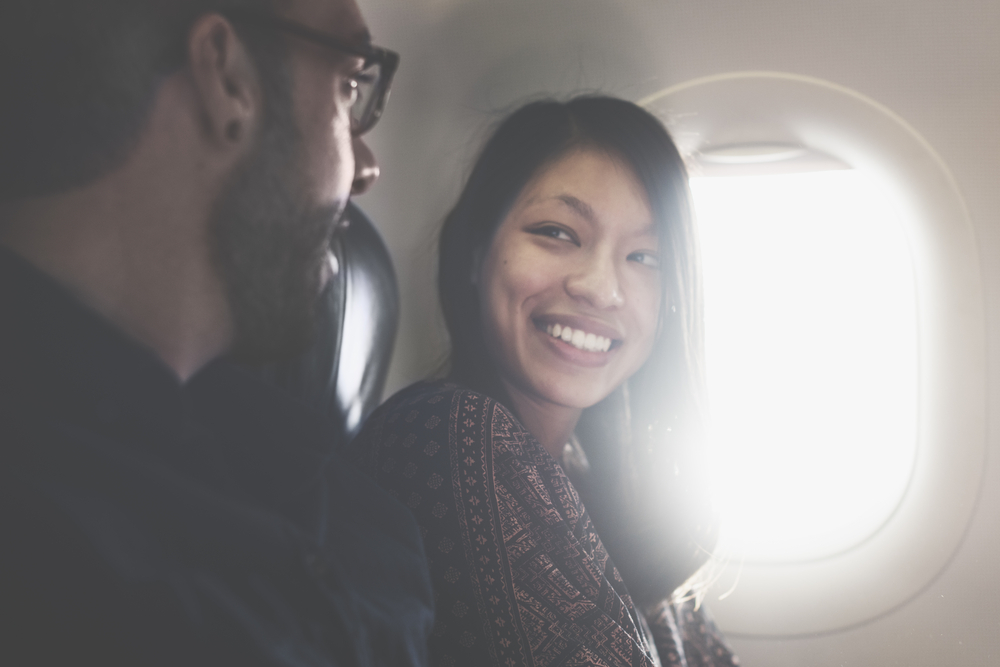 Couple on plane sitting next to each other talking