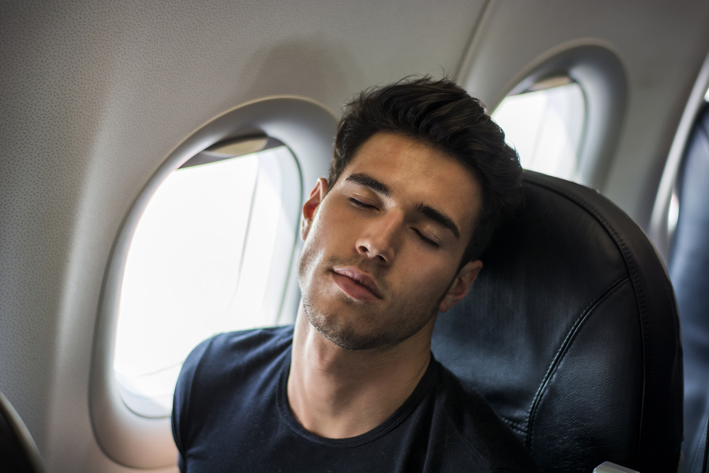 young man sleeping on plane