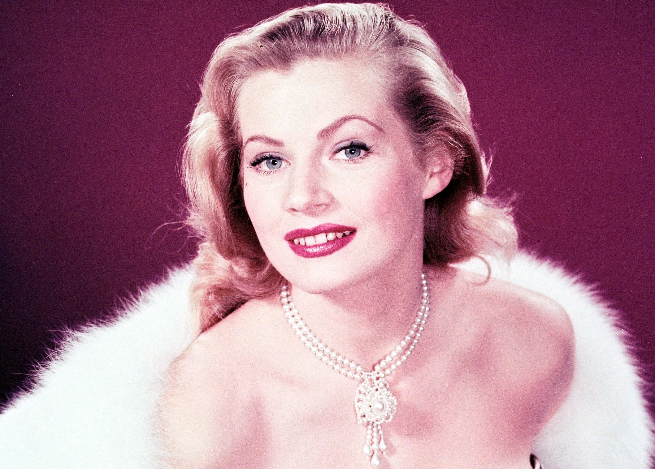 Anita Ekberg, Swedish model and actress, glamorous in a low-cut dress and fur coat