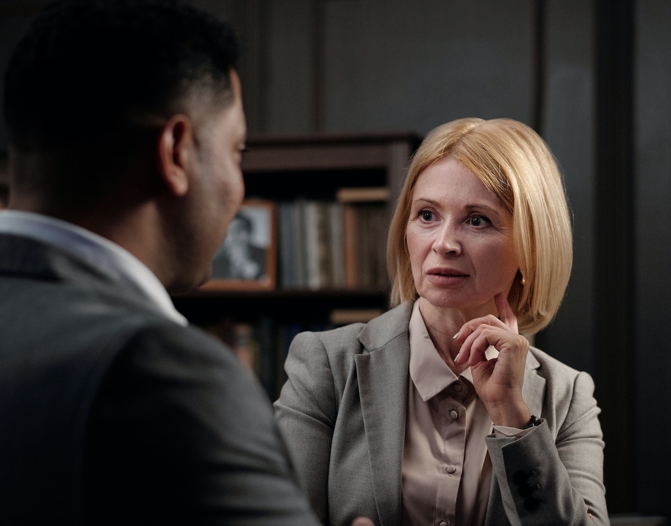 Blonde woman is looking surprised and talking with a man at office.