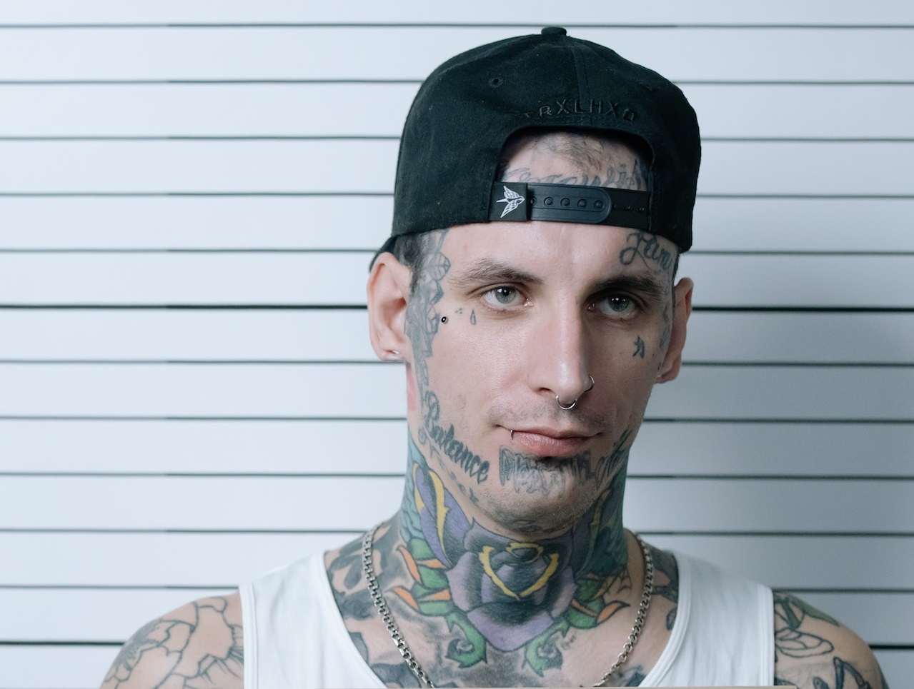 Young man is taking a mug shot at police station.