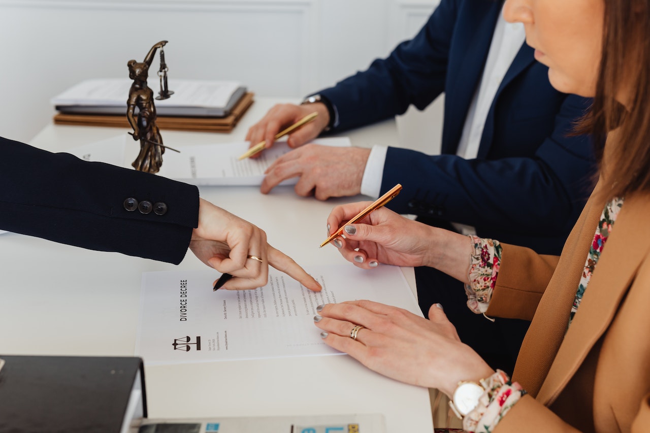 Man and woman sign in divorce papers at courtroom.