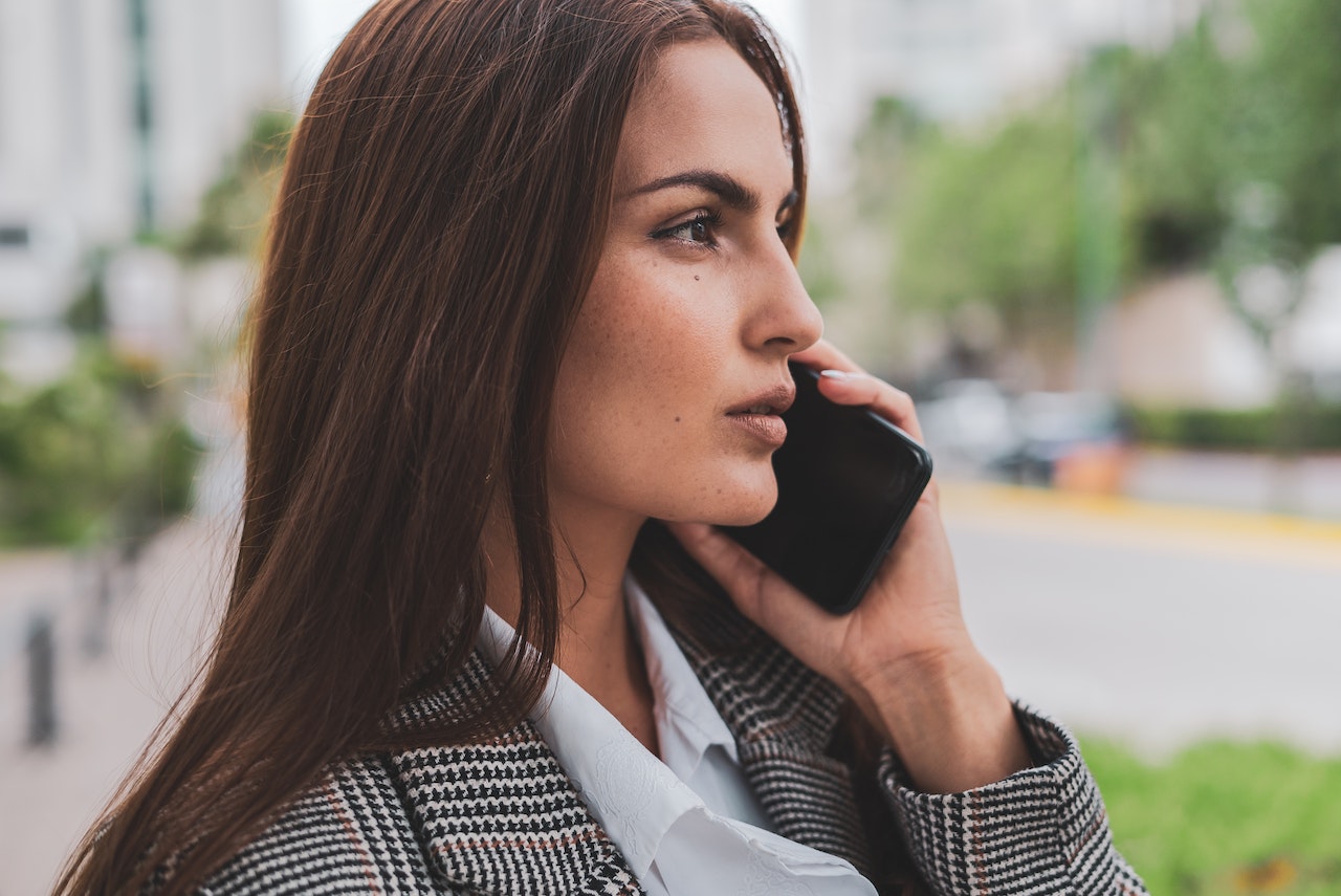 Young woman is talking on the phone on the street.