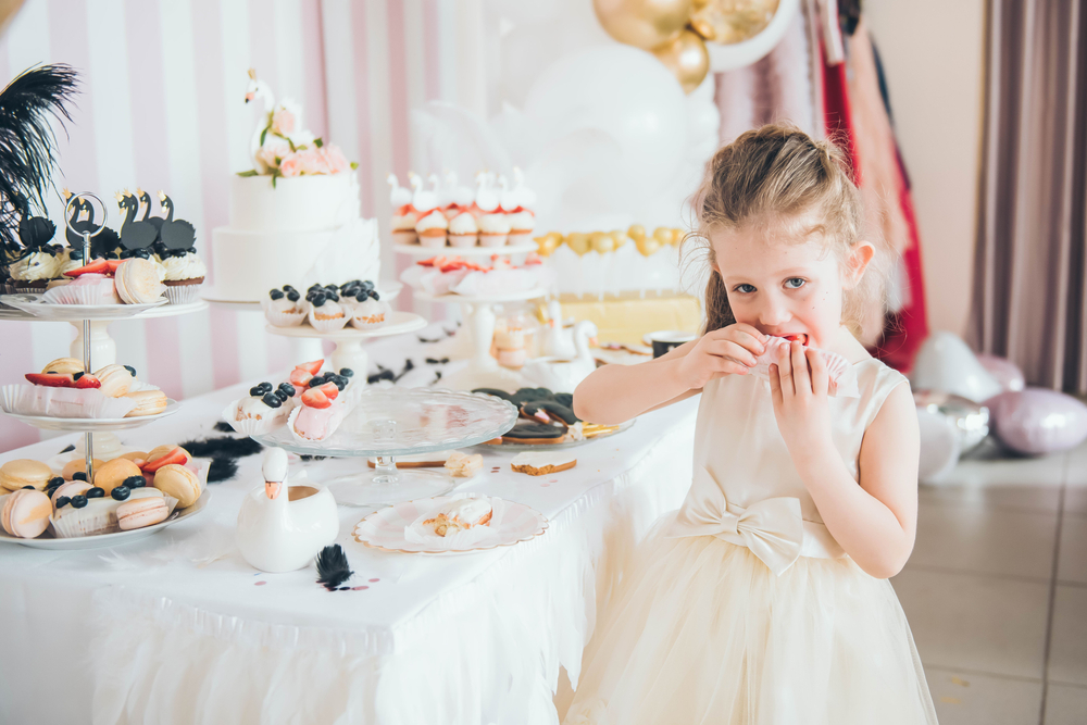 Cute little girl taking sweets from the candy bar