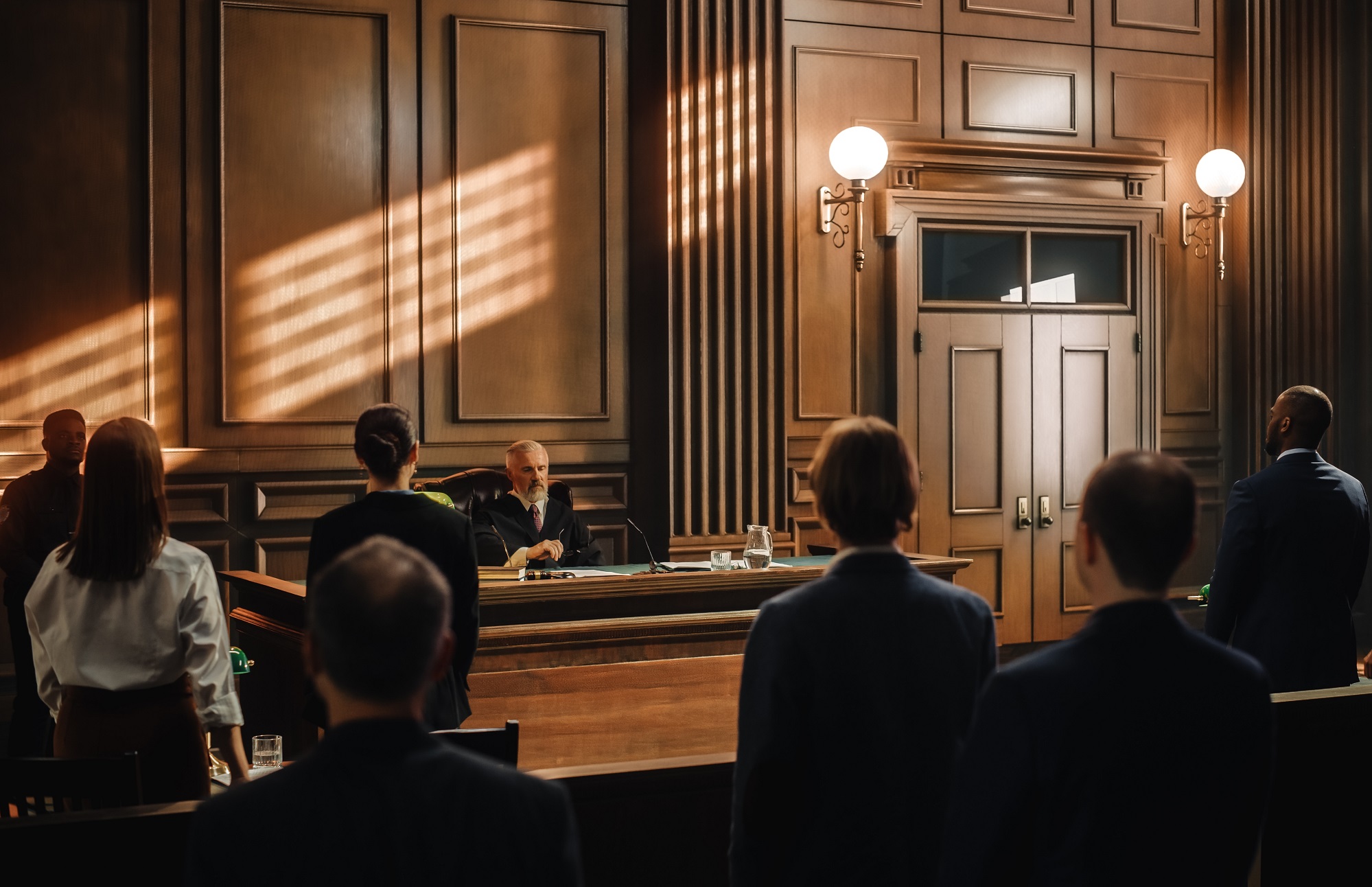 Judge is Sitting in courtroom full of people.