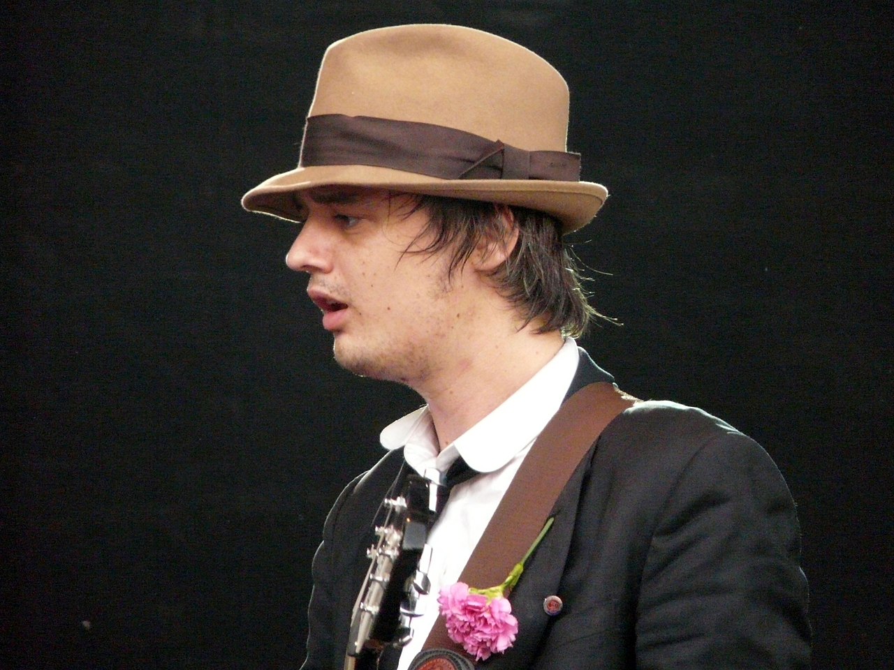 Pete Doherty is performing live on stage on black background - 2008