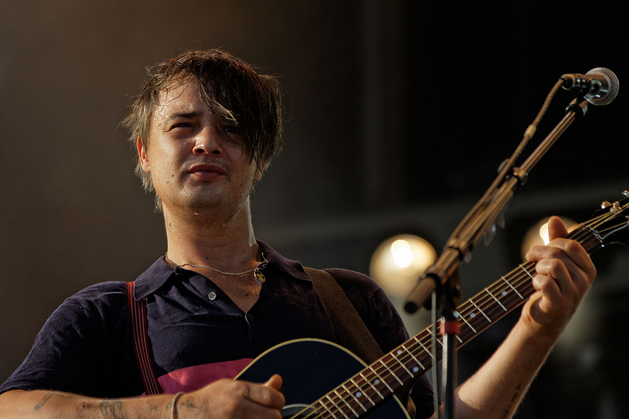Peter Doherty holding a guitar and performing live on stage - 2012