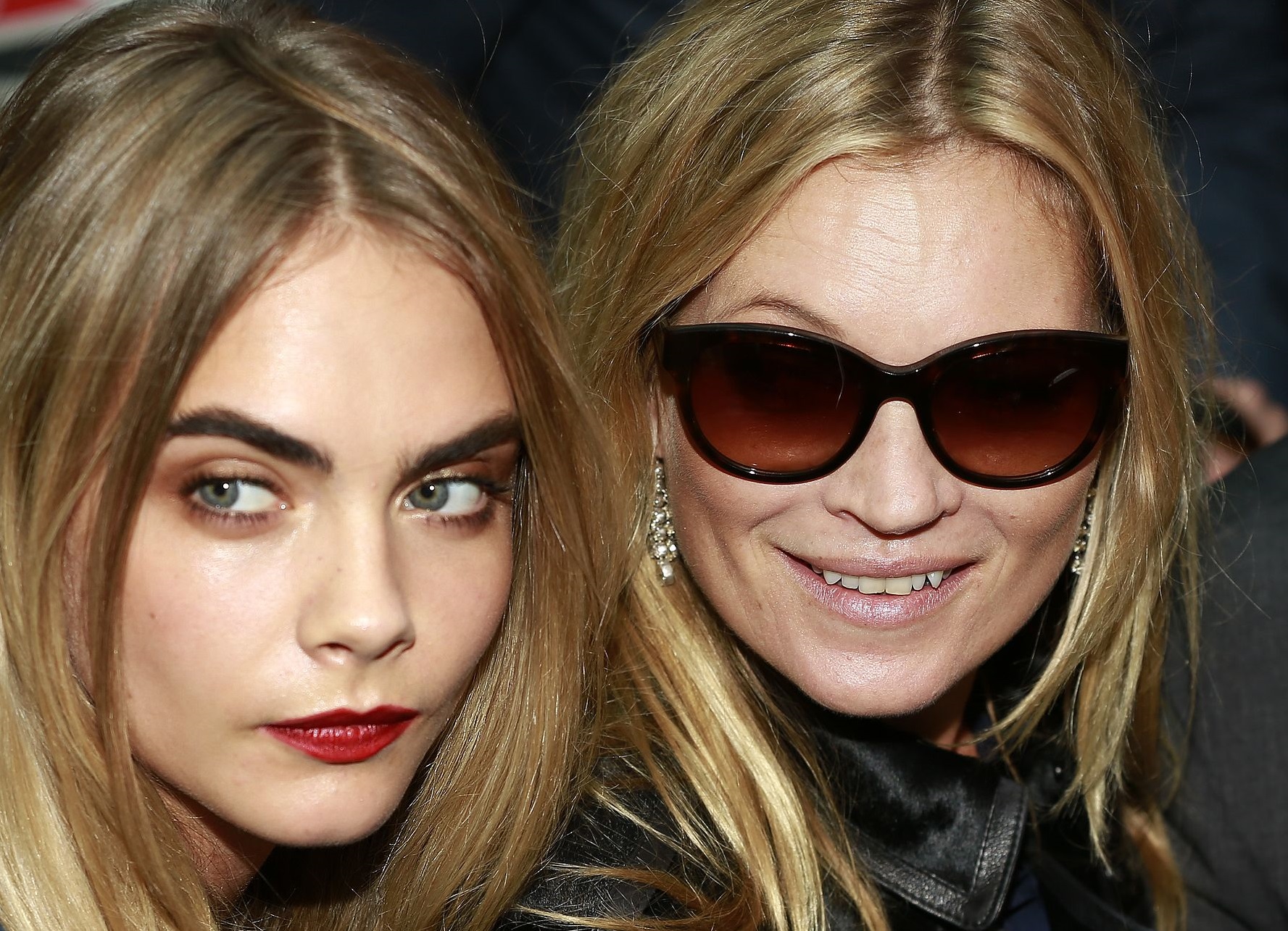 Kate Moss is smiling standing next to Cara Delevingne.
