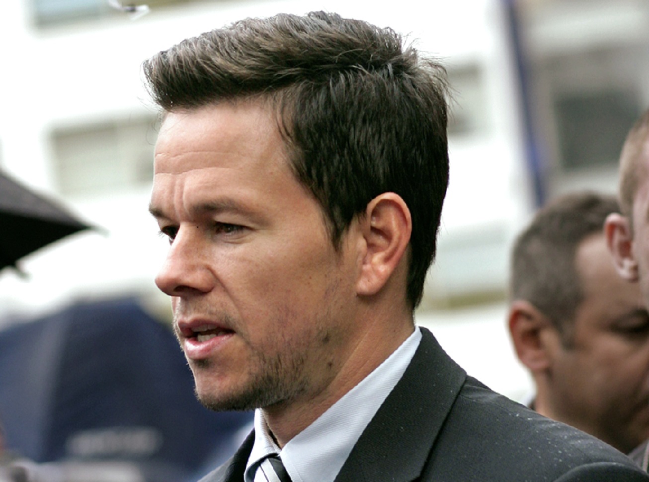 Mark Wahlberg wearing black suit is standing outside - 2007