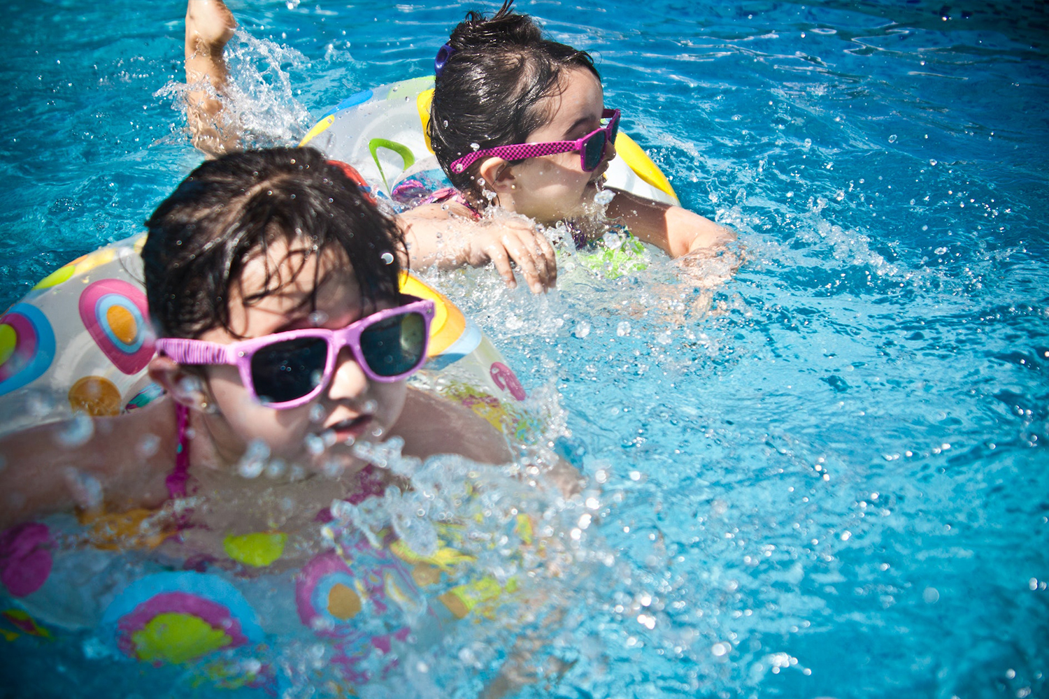 Two Girls Swimming In A Pool