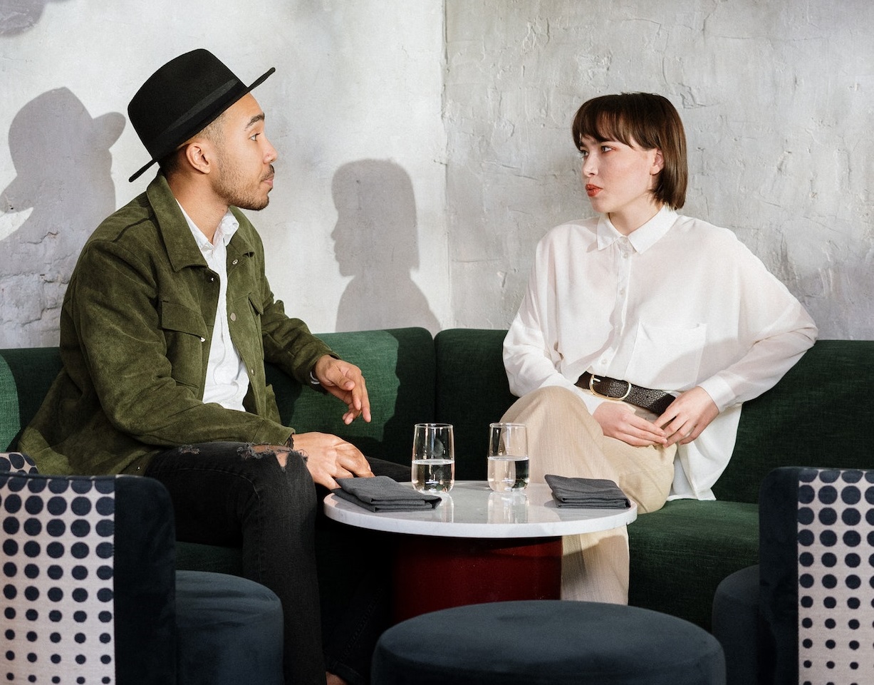 Man and woman are seating and talking in coffee shop.