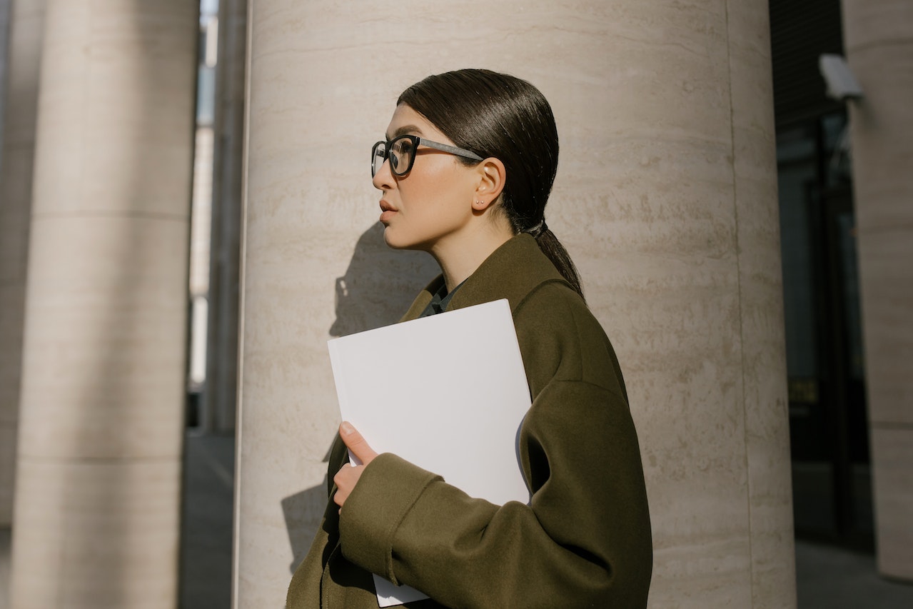 Woman is holding documents at hand and looking sad.