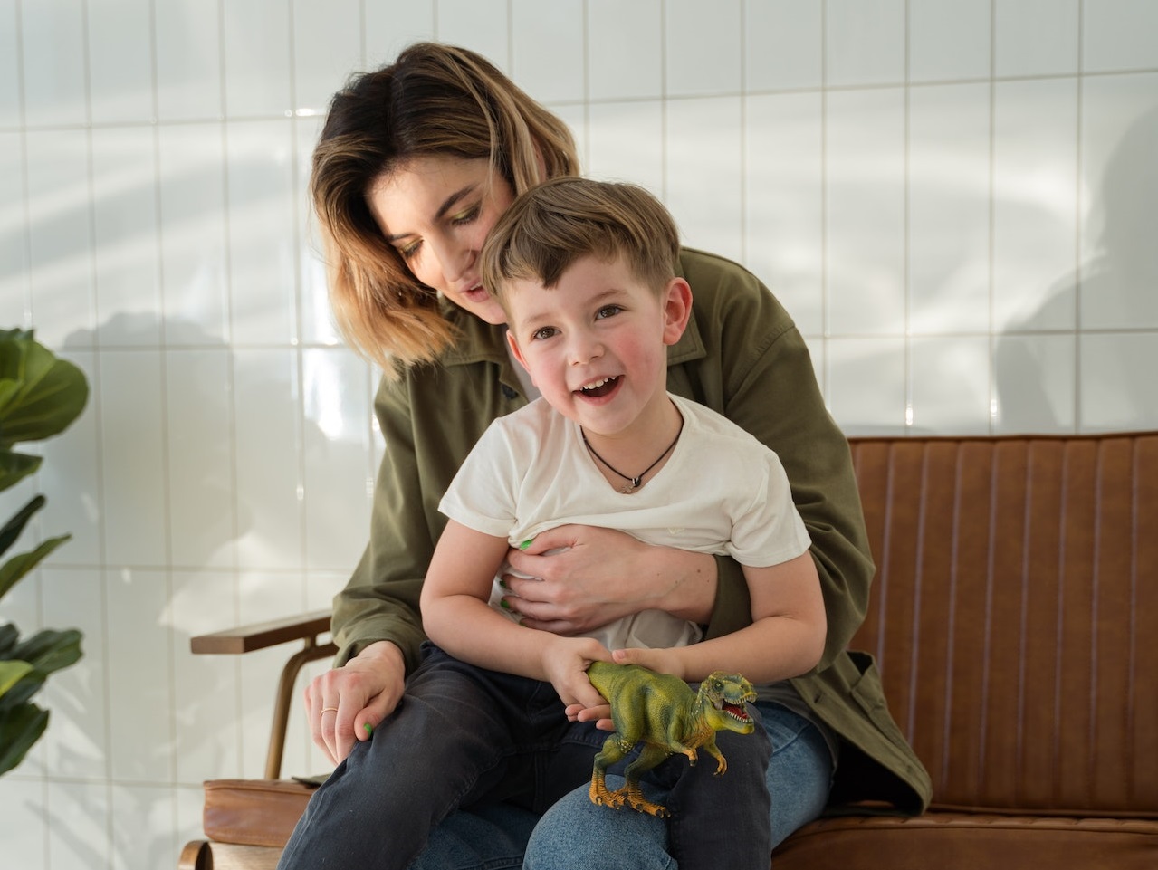 Young woman is holding a kid holding a toy.