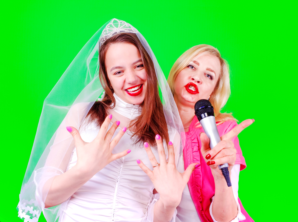 Young bride and her sister in law with a microphone trying to be in the image