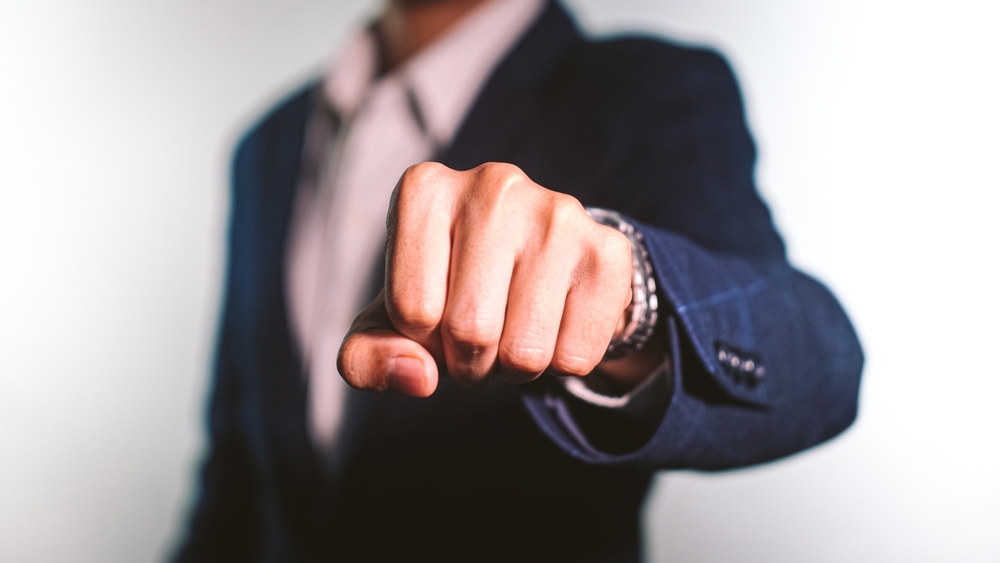 Close up of young man in suit fist bump on white background
