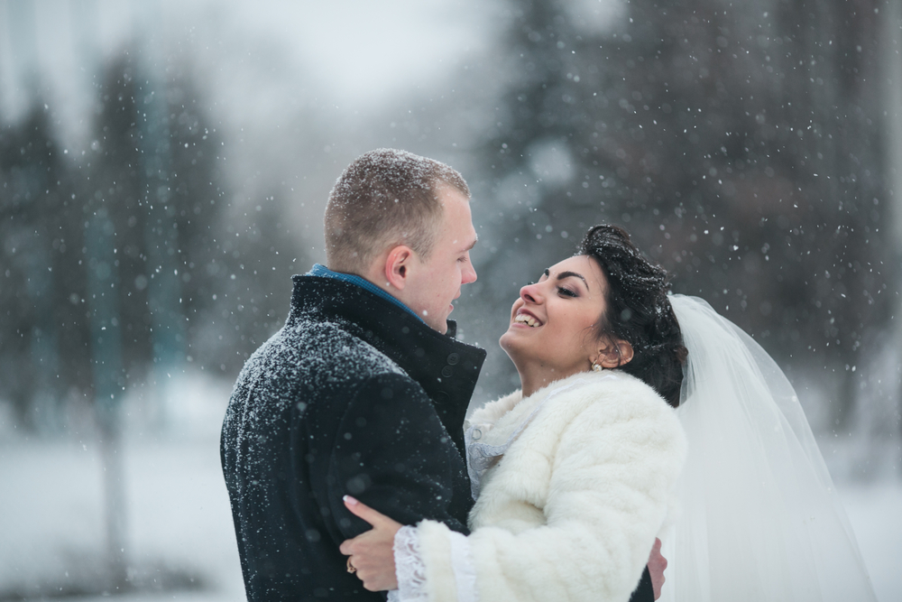 bride and groom in a winter frost with a snow flow