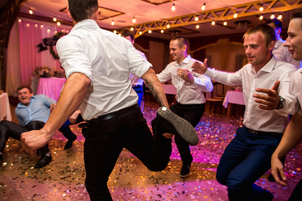 Groomsmen in white shirts  having fun and dancing