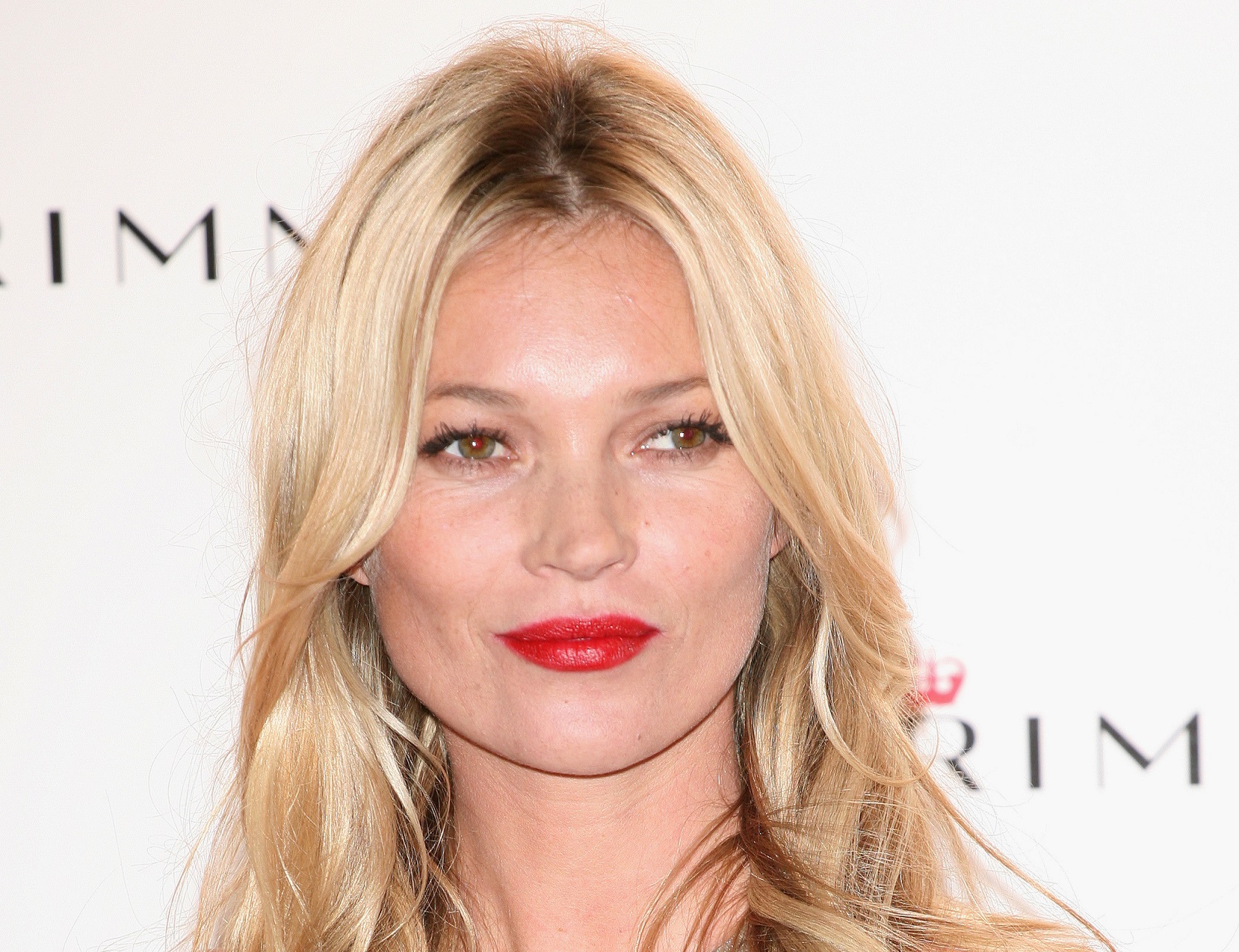 Kate Moss with long hair and red lipstick is looking at side and smiling - 2011