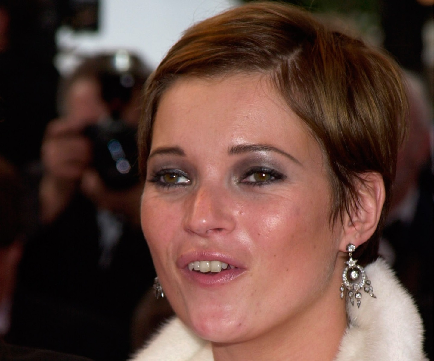 Kate Moss with short hair wearing white coat is looking at side - 2001