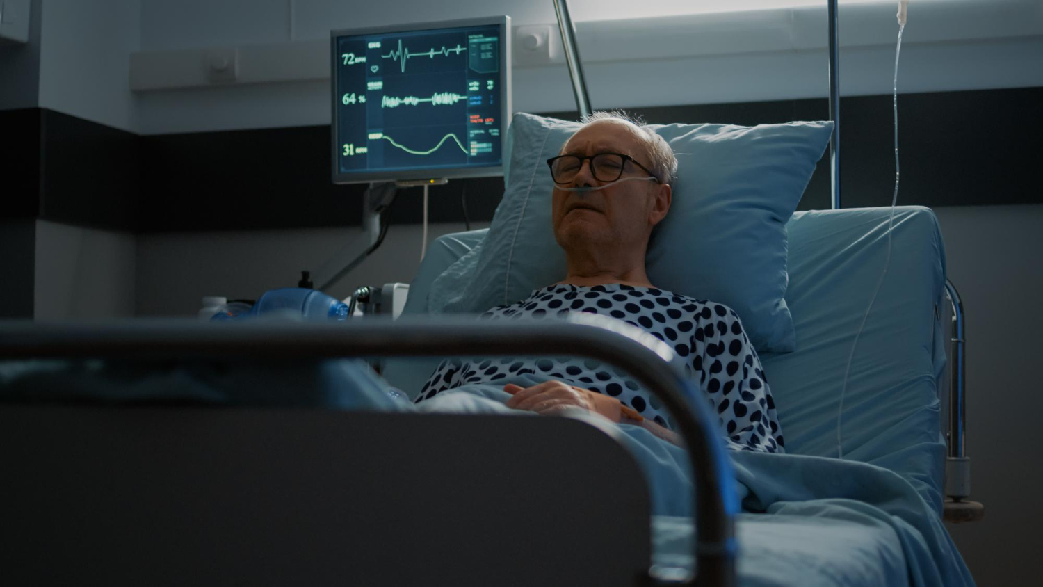 Old man is laying at hospital bed.