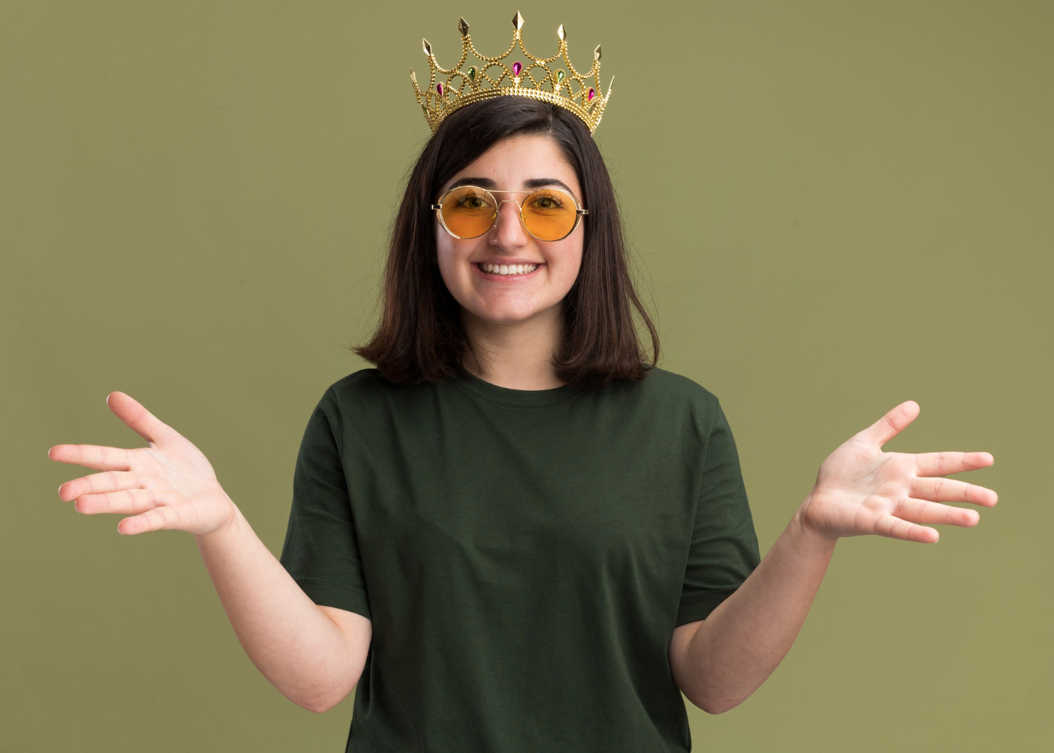 Young woman is wearing a crown on her head and smiling.