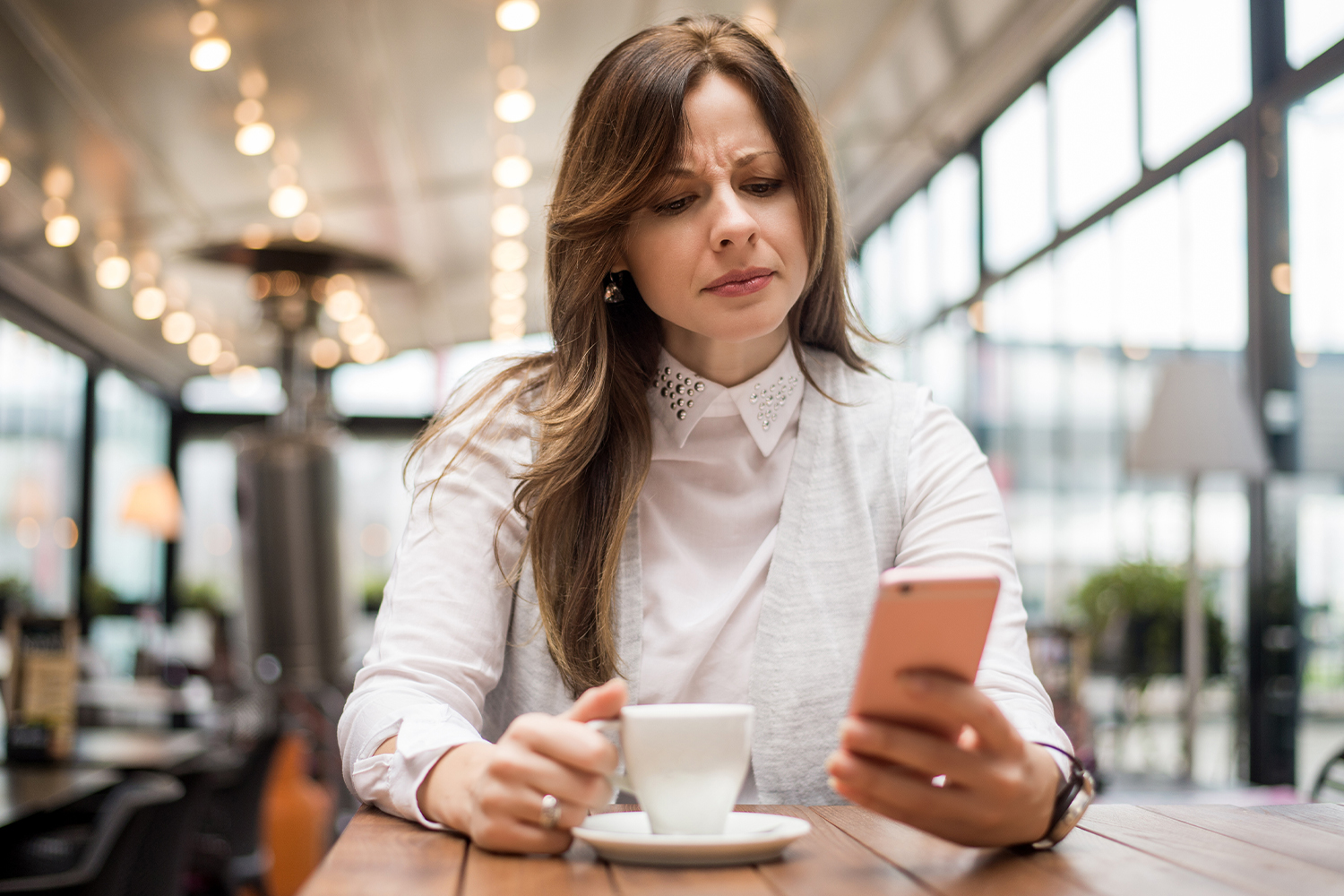 Worried Woman With Coffee And Phone
