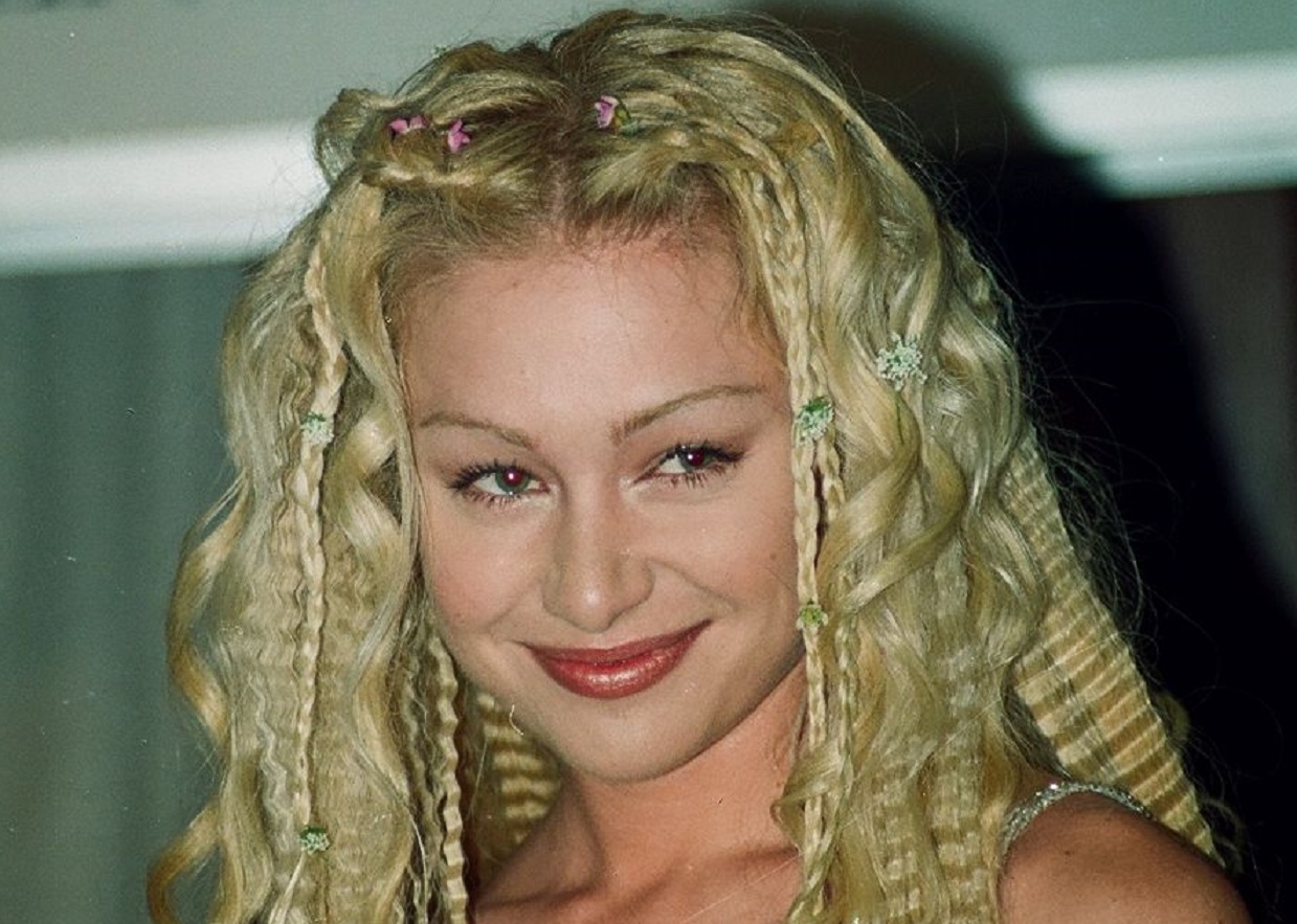 Portia De Rossi is smiling and looking at side - 1999