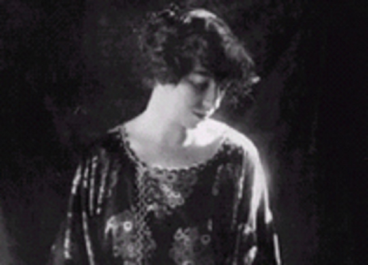 Gertrude Vanderbilt Whitney is looking down on dark background - circa 1920