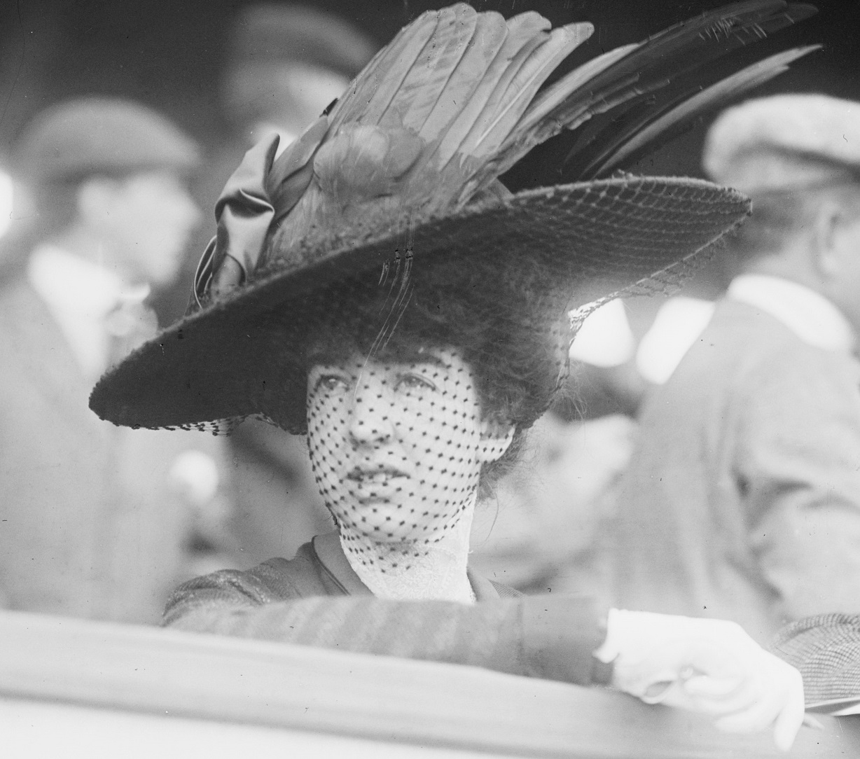 Gertrude Vanderbilt Whitney wearing big black feather hat is looking at side.