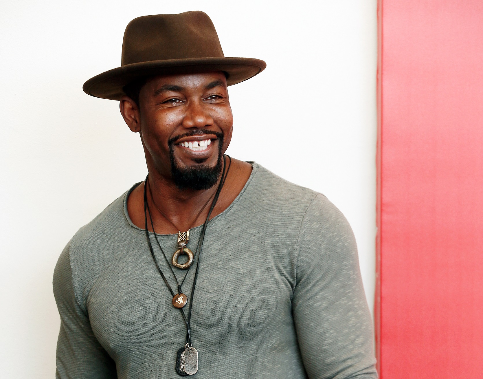 Michael Jai White wearing brown hat is smiling and looking at side - 2018