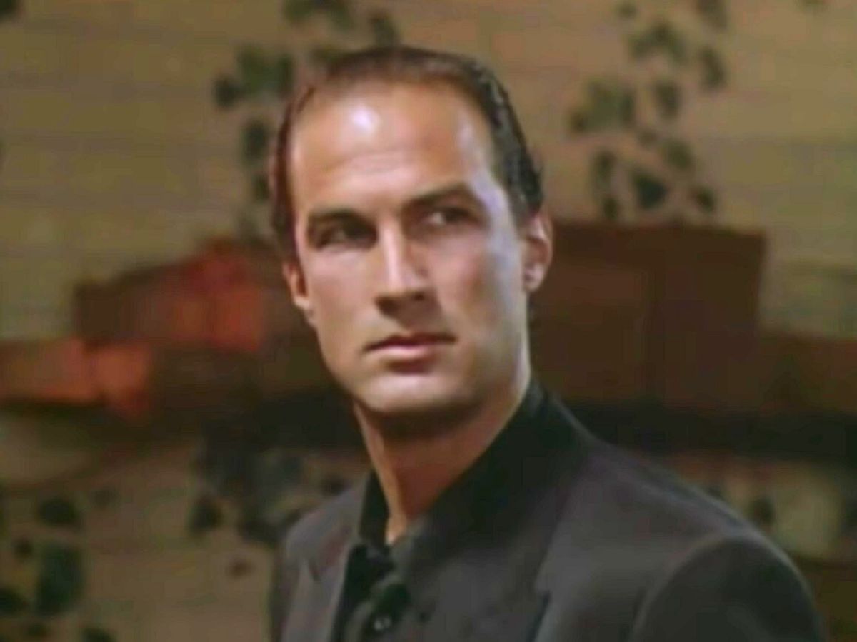 Screenshot: Steven Seagal in black jacket is looking at side - from Above the Law (1988)