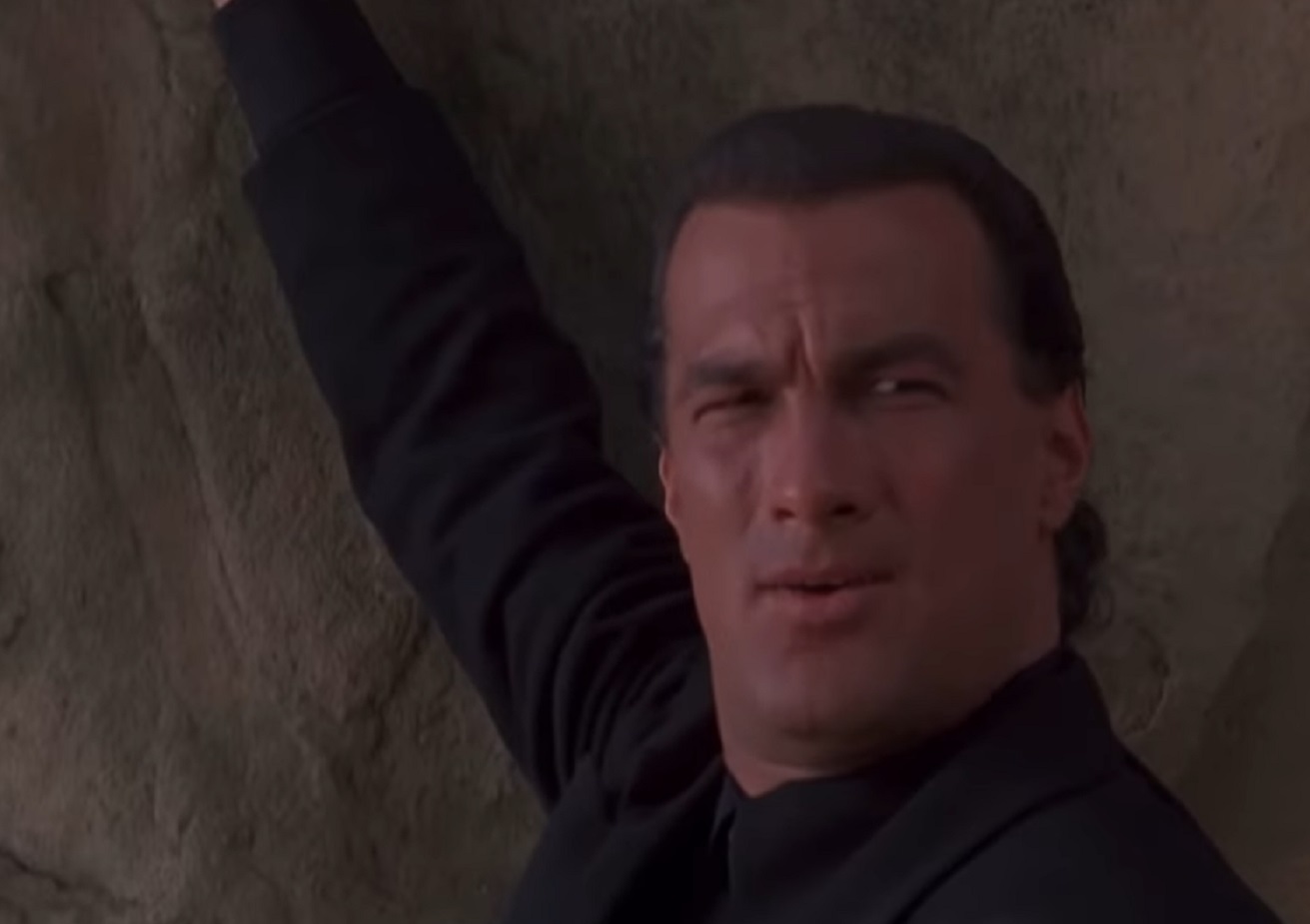 Screenshot: Steven Seagal is standing outside on the rocks - from Under Siege 2- Dark Territory (1995)