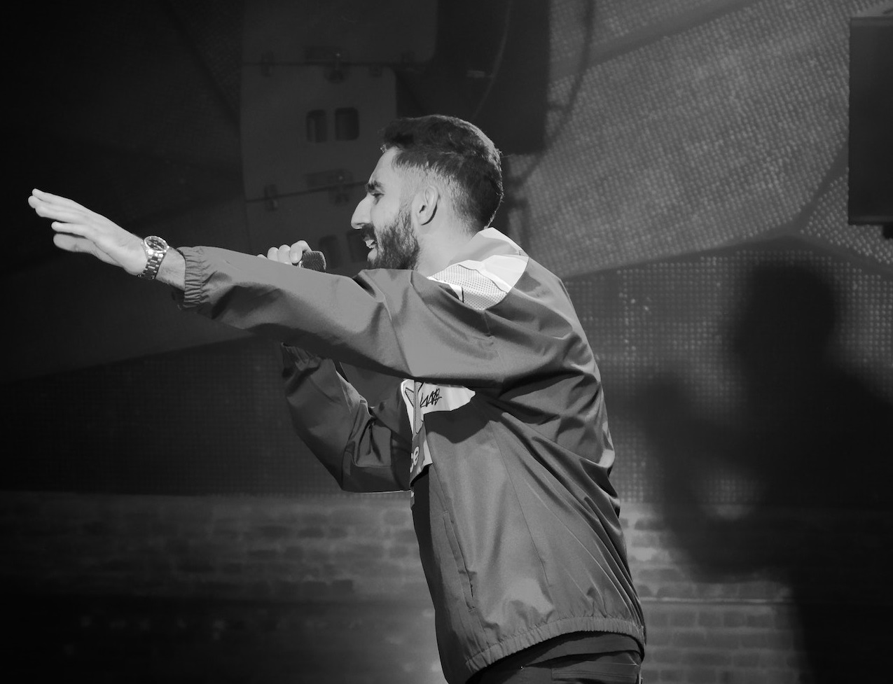 B&W photo of man speaking on the stage.