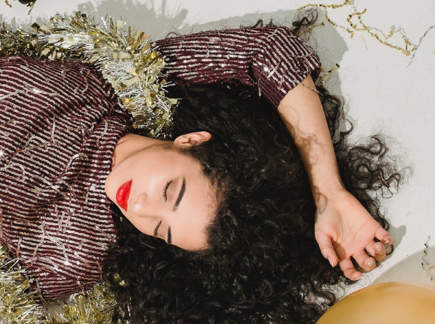 Young woman is laying on the floor with closed eyes.