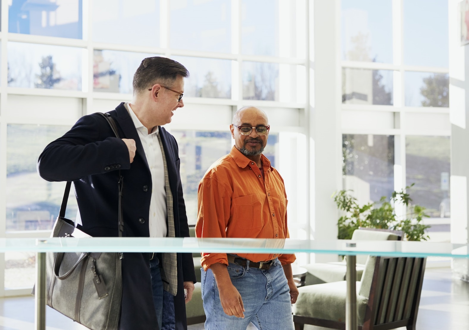 Two young man talking to each other in building hallway.