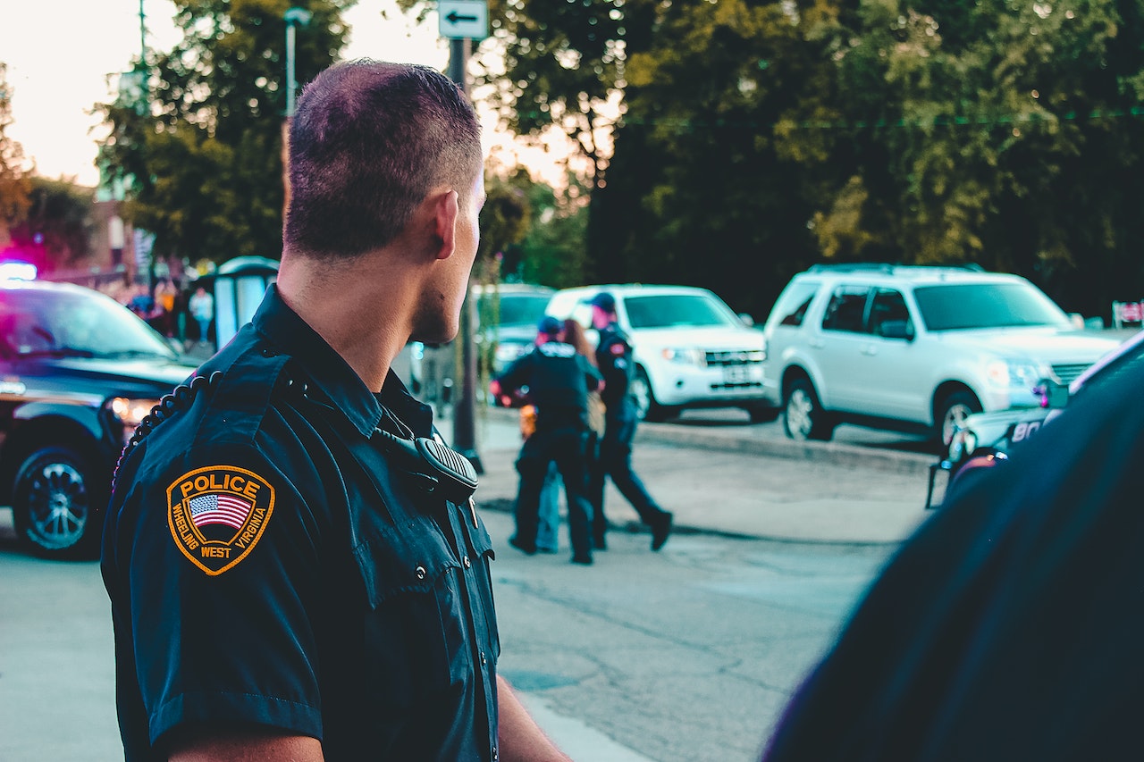 Police officer is looking at police car .
