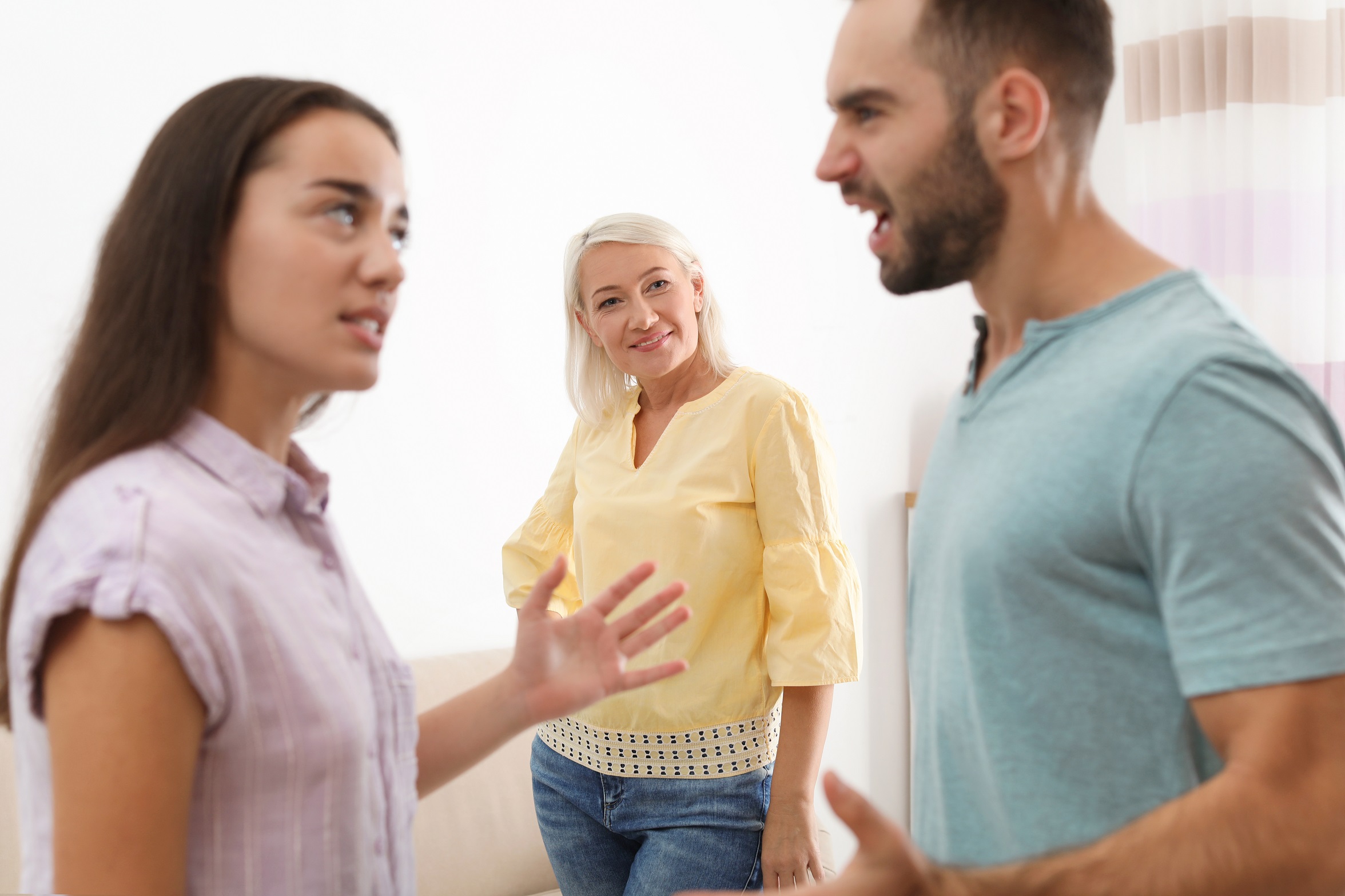 Young couple having argument in presence of other older woman.