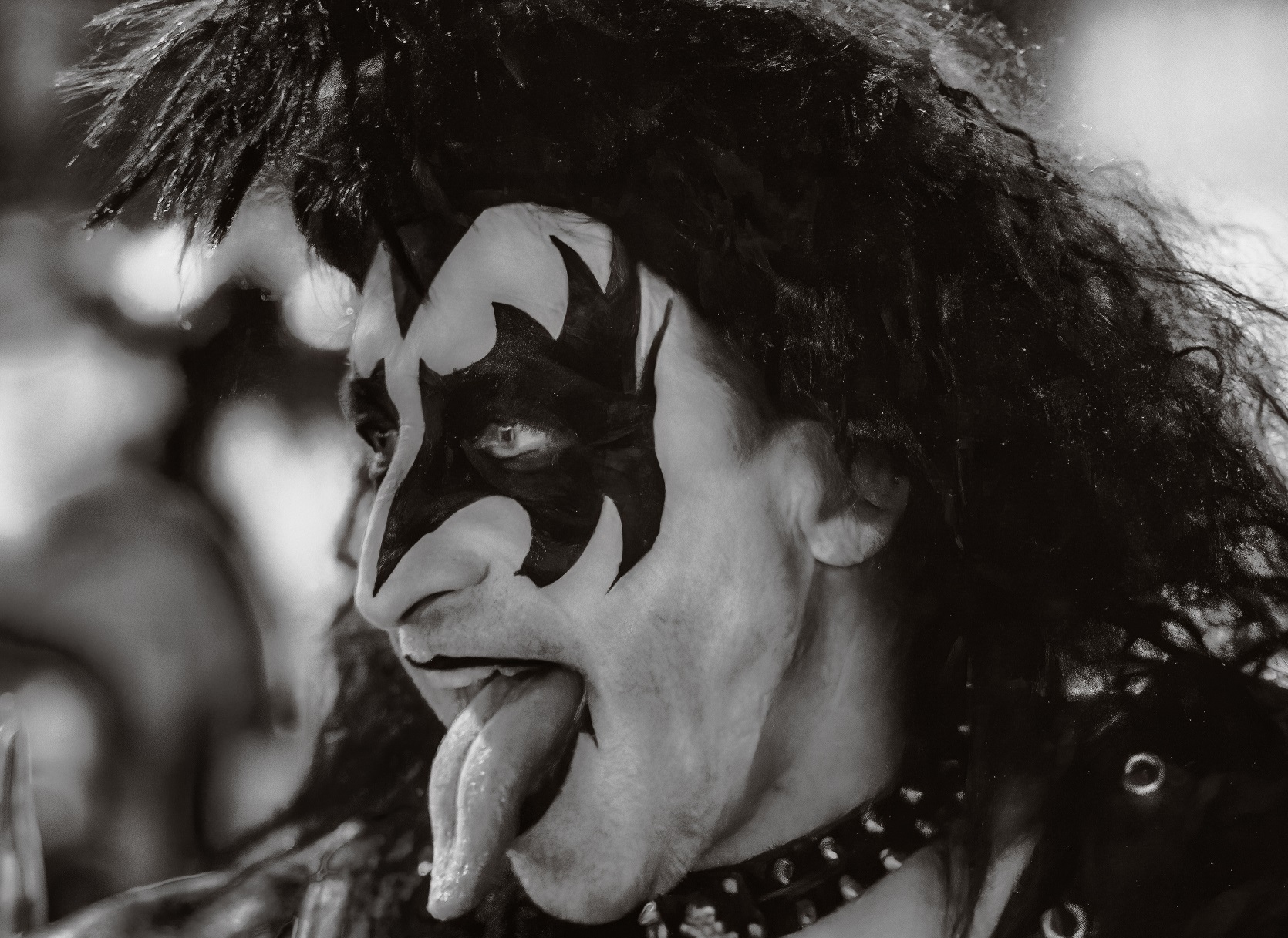 Man wearing make up look a like of Gene Simmons of KISS, looking at side.
