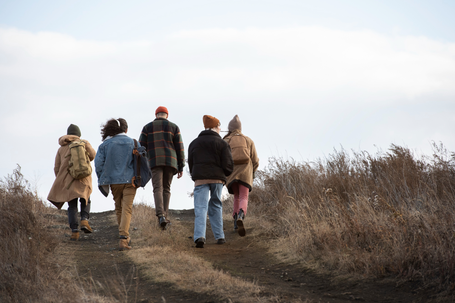 Group of people are walking on a mountain road.