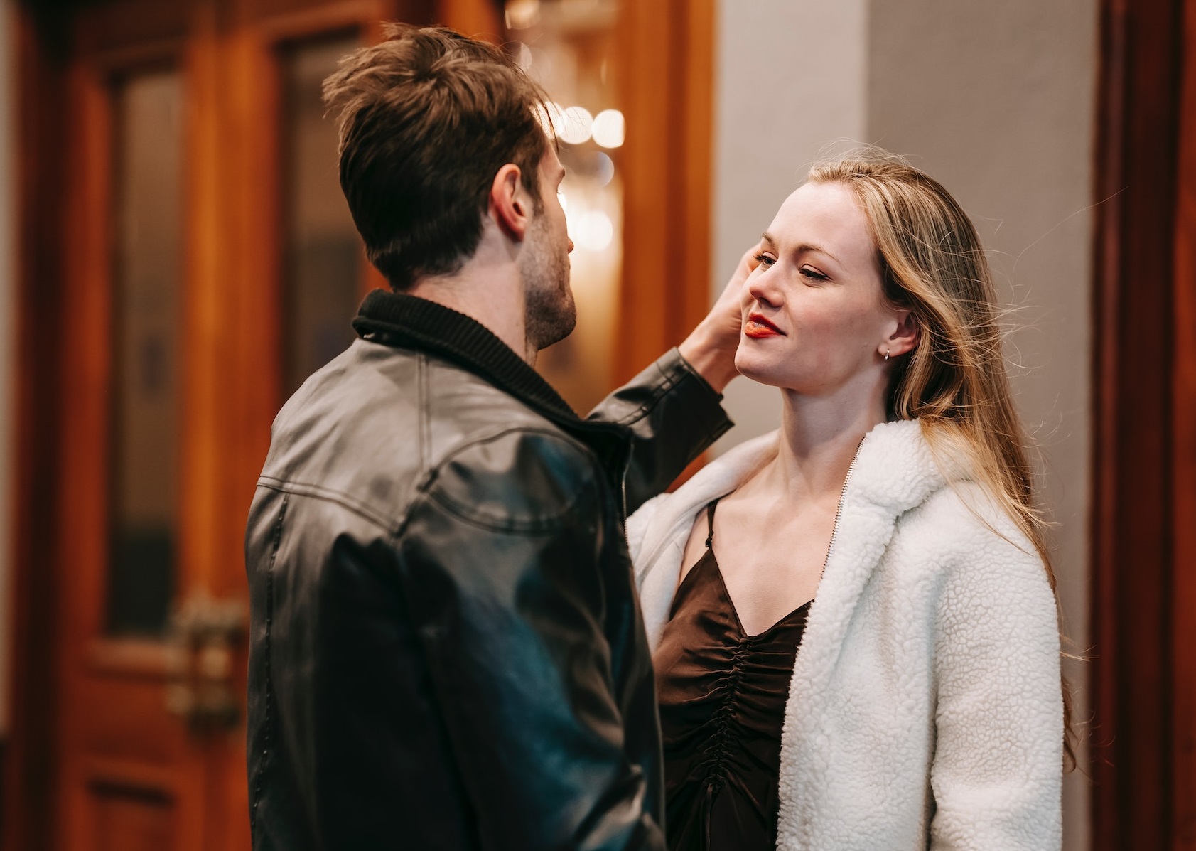 Young man is standing next to a girl and looking at her.