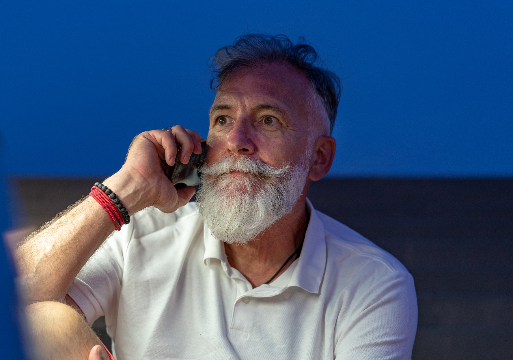 Senior man is talking on the phone with upset face.