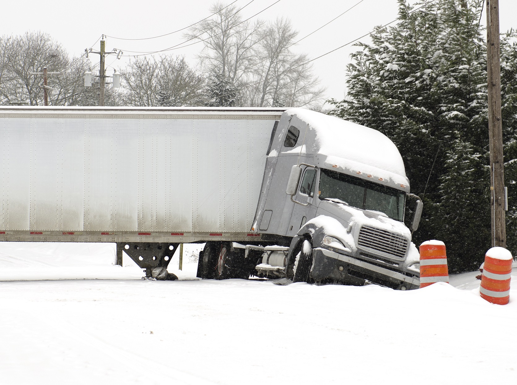 A semi truck jackknife accident into a ditch on snow.