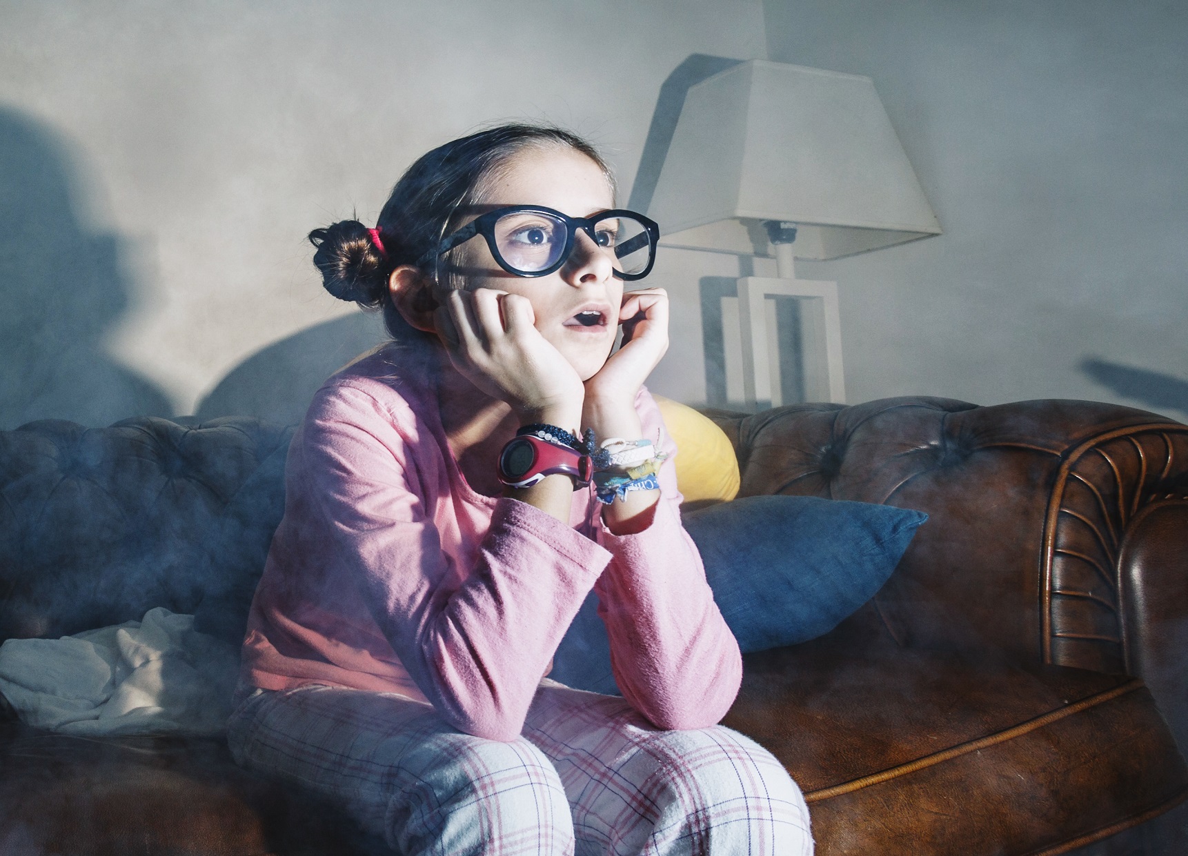 Young girl is watching tv with surprised face.