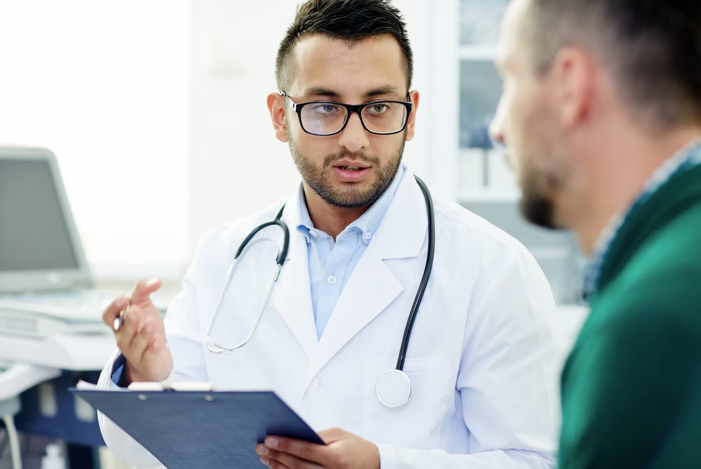 Young male doctor is talking with male patient.