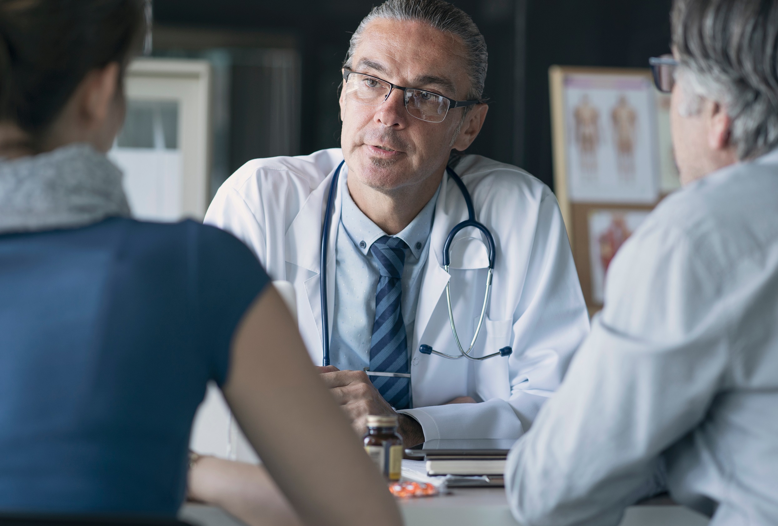 Doctor is talking with family members in his office.
